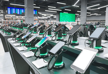 howcase with smartphones in the modern electronics store. Buy a mobile phone. Many smartphones on the shelf of the technology store