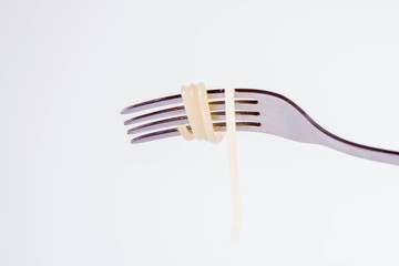 A single cooked spaghetti on a fork