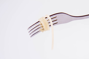 A single cooked spaghetti on a fork