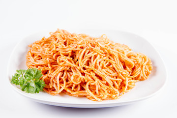 Spaghetti with pesto decorated with parsley on a plate on a white background