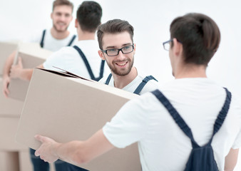 Photo workers pass each other boxes when moving flats.