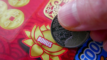 Close up of woman scratching lottery ticket.