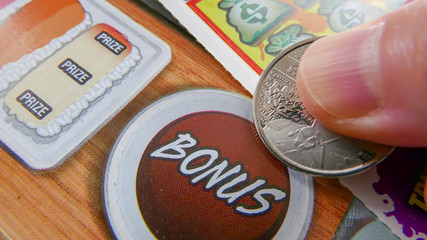 Close up of woman scratching lottery ticket.