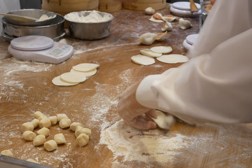 Motion of people are kneading the dough before it to be made dumplings inside restaurant kitchen