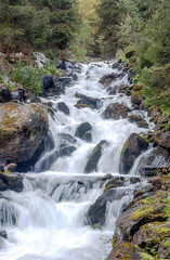 River in the mountains of the Swiss Alps in the Saint Luc valley on a sunny day.