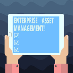 Writing note showing Enterprise Asset Management. Business photo showcasing analysisaging the lifecycle of physical assets Hu analysis Hand Holding Tablet Smartphone Display Unit photo