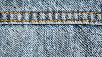 Blue jeans fabric macro seam pattern blurred background. Denim background texture for design.  