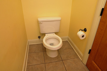 Toilet with seat and cover missing, for repair, in home bathroom