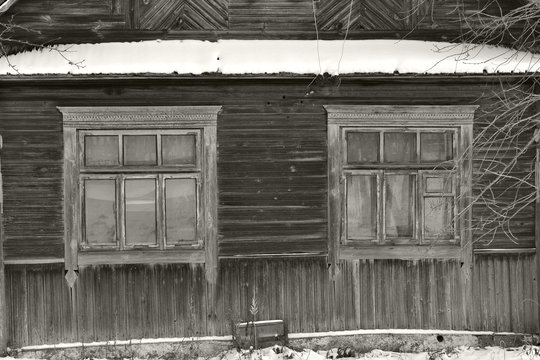Monochrome image of abandoned russian traditional wooden house in winter day