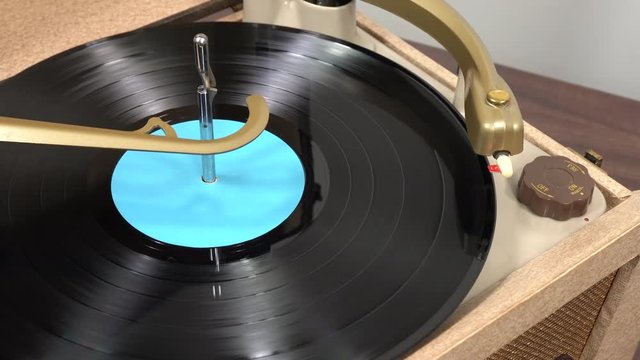 Old portable record player playing vinyl album.