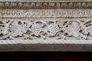 foglie di vite e grappoli; architrave del primo portale sul fianco nord della Cattedrale dell'Assunta a Conversano (Puglie)