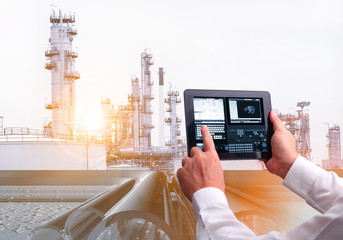 Man hand holding cell phone or tablet  automate wireless  in smart  oil and chemical refinery ...
