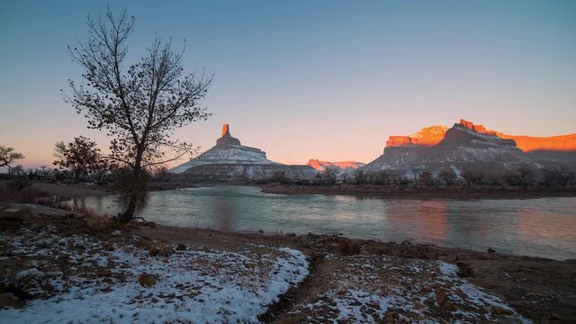 Time lapse of the sun lighting up desert cliffs over Green River on cold winter morning in Utah.