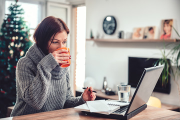 Fototapeta na wymiar Woman working in home office and drinking coffee
