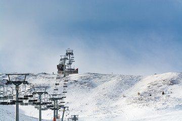 4 January 2019 (Sillian, Austria): The Gadein Chair lift in winter, snowy ski run on the foreground, blue sky on the background