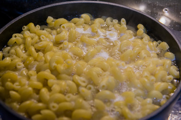 Pasta is cooked in a black cauldron close up, home made, Pasta cooked in a boiling pot on the stove close-up