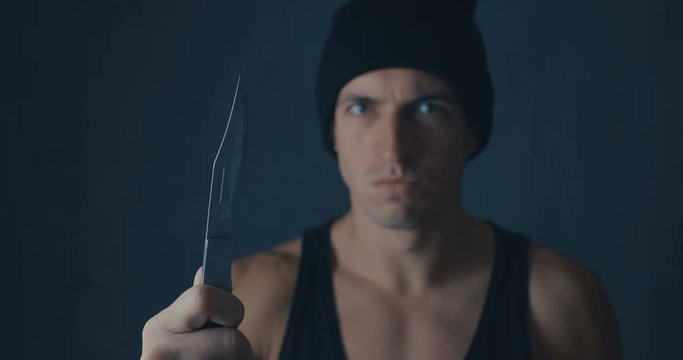 Portrait of Dangerous man in a cap with a knife