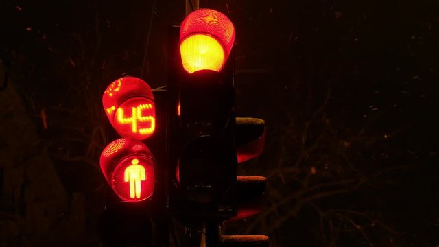 Traffic light switches from red to green in winter at night