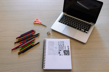 Trabajo de arte con colores y laptop para dibujar a color en papel blanco sobre mesa