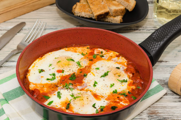 Homemade breakfast shakshuka of fried eggs with tomatoes. Shakshuka. Eggs in tomato sauce for breakfast. 