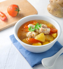 A cup of chicken soup with potatoes 