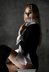 Young sexy sensual blonde fashion woman portrait posing in white man shirt and jacket on dark