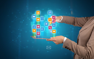 Female elegant hand holding tablet with colourful application icons