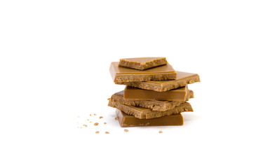 stack of chocolate pieces and crumbs on white background selective focus