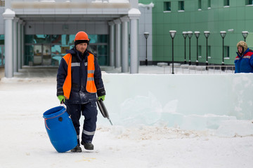 Portrait of an installer in an orange vest and helmet