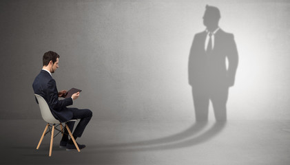 Fototapeta premium Humble businessman staying and offering stuffs to a huge businessman shadow 