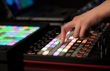 Dj hand remixing music on midi controller

