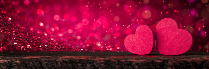 Two Pink Valentine's Hearts Standing On Wooden Table With Soft Romantic background