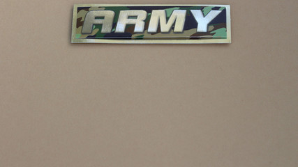 army sign on a tan background with writing space