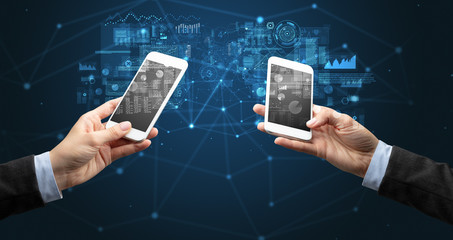 Close up of two hands holding smartphones to sync business data