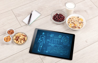 Naklejka premium Healthy food composition with tablet. Body diagnosis on the screen