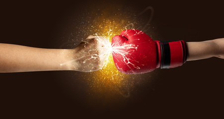 Fototapeta na wymiar Two hands fighting with orange dust, spark, glow and smoke concept 