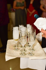 Waitress holding a dish of champagne and wine glasses at some festive event,