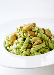 Delicious chicken with green sauce pasta over white background