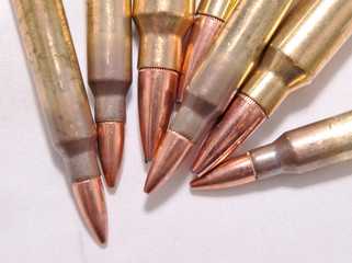 Seven rifle bullets, .223 and .300 Winchester Magnum calibers on a white background 