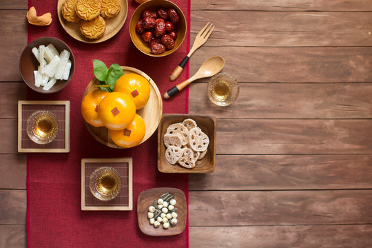 Flat lay Chinese New Year food and drink group of objects still life on red and rustic wooden background. Translation of text appear in image: Prosperity.