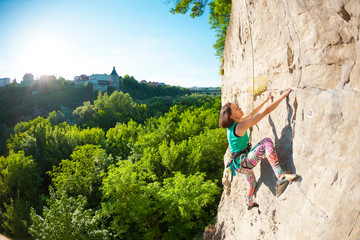 Obraz premium The woman climbs the rock.
