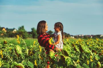 Mom and daughter in the field with sunflowers