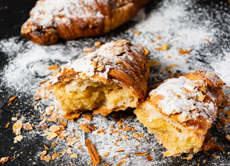 Croissants with almonds on the black background