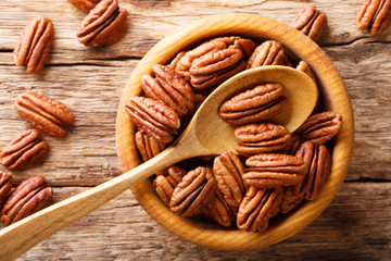 Raw pecan nuts in a bowl close-up. horizontal top view