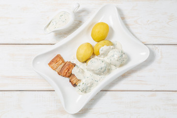 Roast pork belly with boiled potatoes and cream sauce. The view from the top. Copy-space.