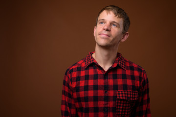 Man wearing red checkered shirt and thinking