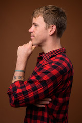 Fototapeta premium Profile view of man wearing red checkered shirt while thinking