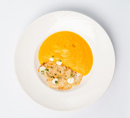 Pumpkin and carrot soup with cream with croutons on the white background