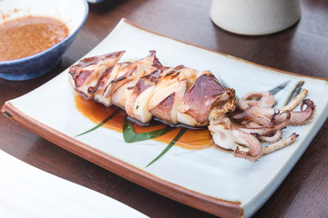 grilled squid that serve in cutted with teriyaki sauce and spicy sea food sauce on japanese plate
