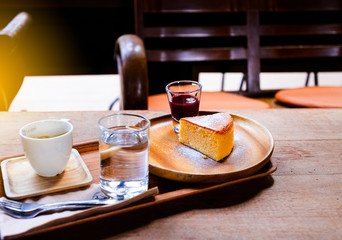 Black coffee in a white cup with bread and strawberry jam on a wooden table, suitable for a warm morning.